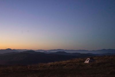 Scenic view of field against clear sky at sunset