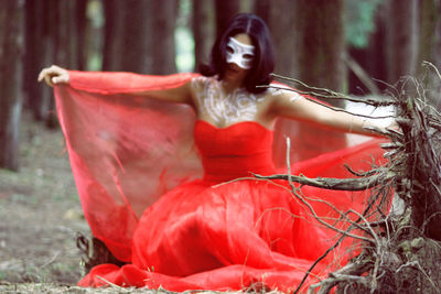 Woman wearing mask against trees at forest