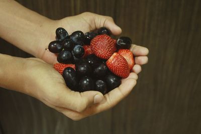 Close-up of hand holding strawberries