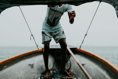 Man fishing in sea against sky