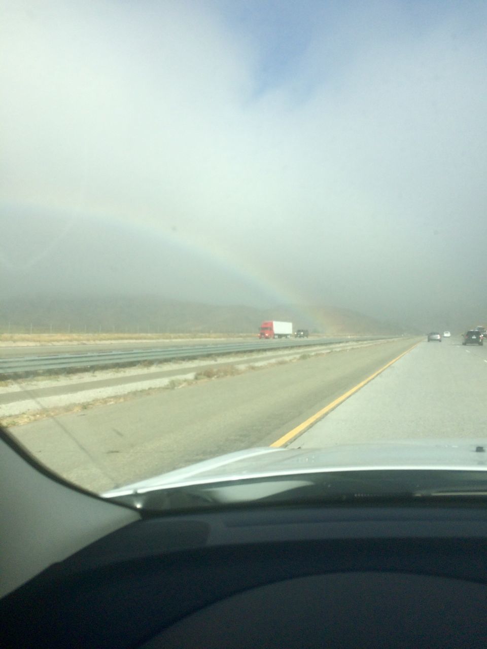 CAR ON ROAD AGAINST SKY SEEN THROUGH WINDSHIELD