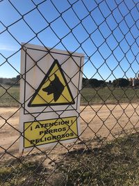 Information sign on field seen through chainlink fence