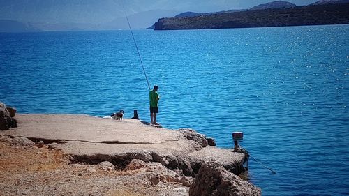 Rear view of man fishing in sea