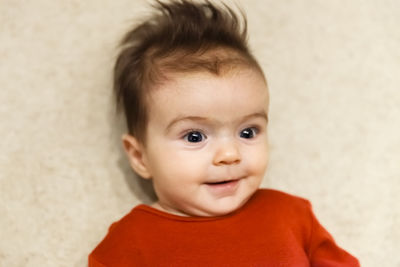 Close-up of baby girl looking away on bed