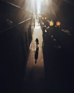 Silhouette people walking on road in city