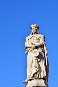 Low angle view of statue against blue sky