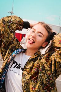 Portrait of young woman standing against white background