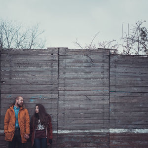 Friends standing against wall