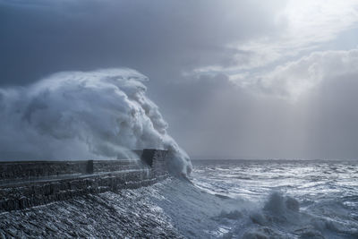 Waves splashing on sea against sky