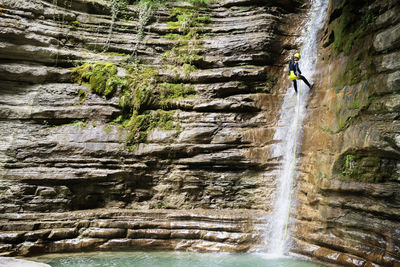 Woman rappelling down into lake