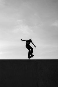 Full length of boy jumping against sky