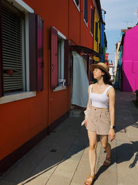 Full length of woman standing on footpath