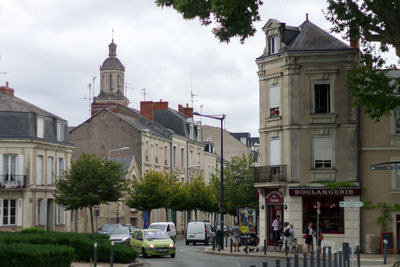 Street by buildings against sky in city