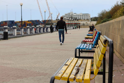 Rear view of people walking on road in city
