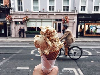 Man holding ice cream cone on street