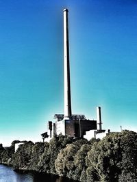 Low angle view of factory against clear blue sky
