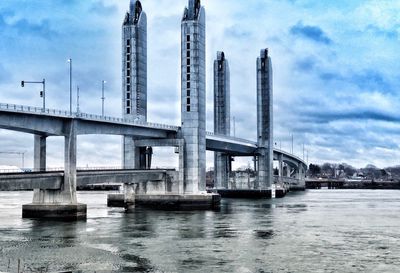 Low angle view of bridge over river against sky