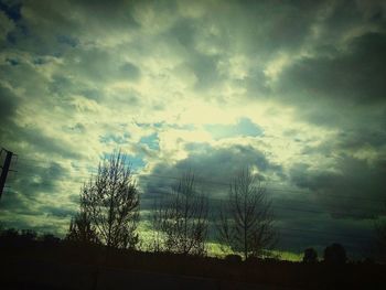 Low angle view of silhouette trees against sky