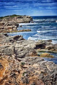 View of calm blue sea against cloudy sky