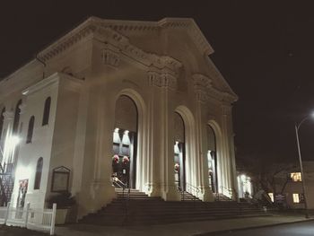 Low angle view of illuminated building against sky at night