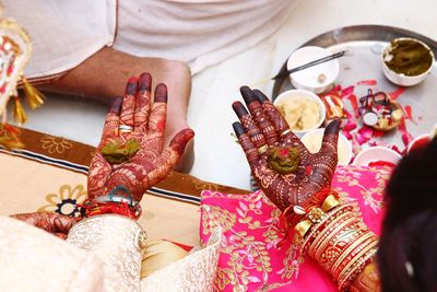Cropped image of bride and groom performing ritual during wedding ceremony