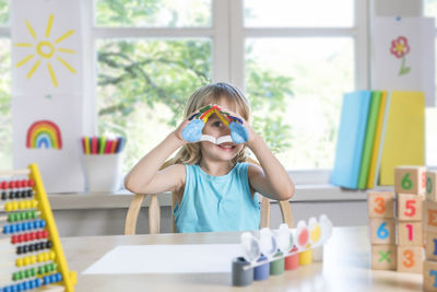 Portrait of happy girl on table at home
