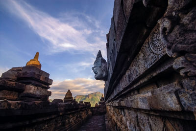 Sculptures at temple against sky