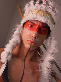 Portrait of shirtless young man wearing headdress