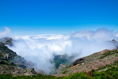 Scenic view of mountains against blue sky