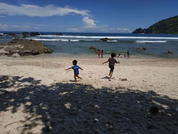 People on beach against sky