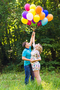 Rear view of two women holding balloons