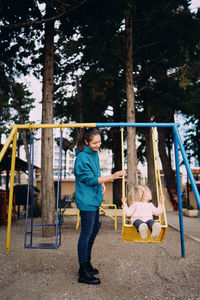 Rear view of man swinging in playground