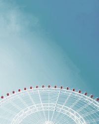 Low angle view of rollercoaster against clear blue sky