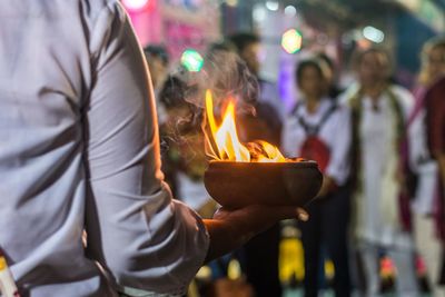 Close-up of people holding burning candles