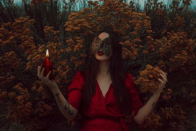 Young woman holding candle and leaves