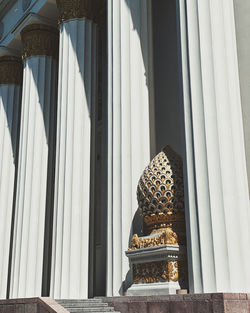 An openwork white vase in indian style hides behind ancient columns