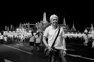 People standing on street in city at night