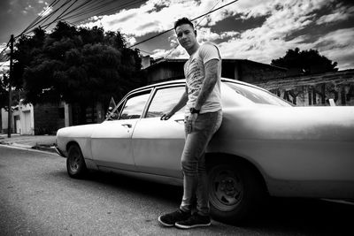Man standing by car in city