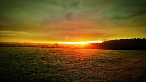 Scenic view of field against sky during sunset