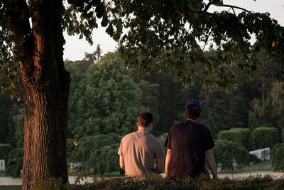 Rear view of friends relaxing in park