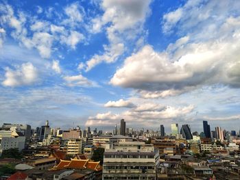 Buildings in city against cloudy sky