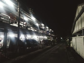 Train on illuminated railroad tracks against sky at night