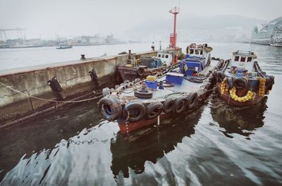 High angle view of boats moored at harbor against sky