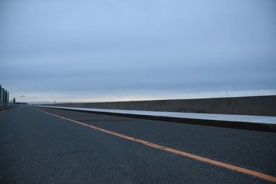 Surface level of empty road against sky