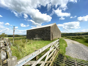 Old stone farm building, with trees and hills, in the distance in, cow ark, clitheroe, uk