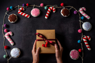 Hands hold christmas gift box on dark backround