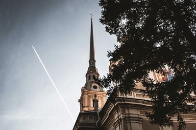 Low angle view of trees and building against sky