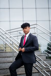 Full length of a young man standing against wall