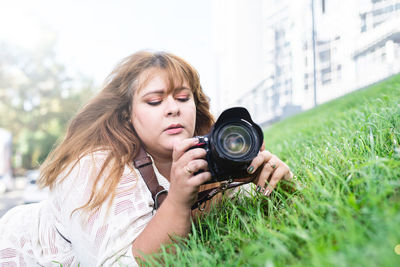 Portrait of young woman photographing