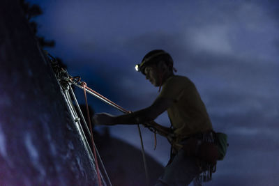 Side view man belaying climber in the night from top of chief squamish